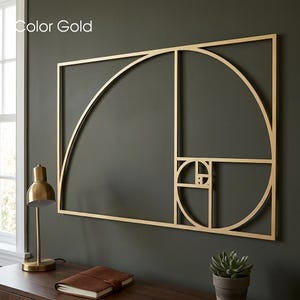 Peut inclure: Une décoration murale en métal doré représentant le motif géométrique de la spirale du nombre d'or. Le cadre rectangulaire contient une série d'arcs et de carrés interconnectés formant la séquence mathématique, fixée sur un mur sombre.