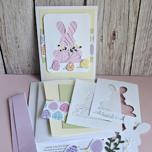 May include: Easter craft kit with a pink bunny card, floral details, and decorative eggs. Includes cardstock, instructions, and templates for DIY crafting. Ideal for creating Easter cards and decorations.