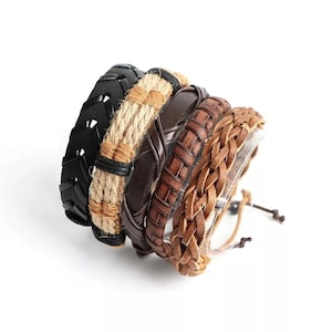 May include: A set of five bracelets featuring a black rubber band with a tire tread pattern, a tan jute rope band, a smooth dark brown leather band, a medium brown woven leather band, and a light brown braided leather cord with adjustable ties.