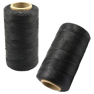 May include: Two cylindrical spools of black thread, each featuring a tightly wound, textured surface and a visible light brown cardboard core at the center. The thread is wrapped in a crisscross pattern around the spool, creating a uniform appearance.