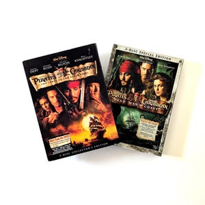 May include: Two DVD cases featuring Pirates of the Caribbean: The Curse of the Black Pearl and Dead Man's Chest. The covers display movie titles, cast names, and character imagery including Johnny Depp, Orlando Bloom, and Keira Knightley.