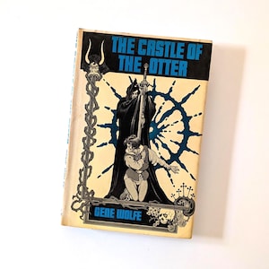 May include: Vintage paperback book titled "The Castle of the Otter" by Gene Wolfe. The cover features a black-robed figure holding a sword over a kneeling person, with a blue and white design. The book has a worn, aged appearance.