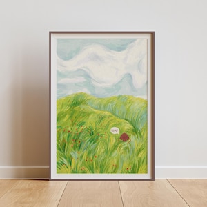 Puede incluir: Una impresión artística enmarcada representa un paisaje de dibujos animados. Un personaje redondo y marrón está en un campo de hierba verde, con un bocadillo que dice "GUAD!". El cielo es azul claro con nubes blancas.