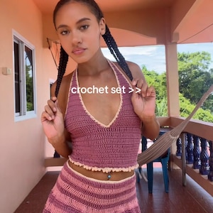 Puede incluir: Conjunto de crochet en tonos rosa y malva. El top halter y los shorts presentan un punto texturizado con un borde festoneado. El texto "crochet set >>" es visible.