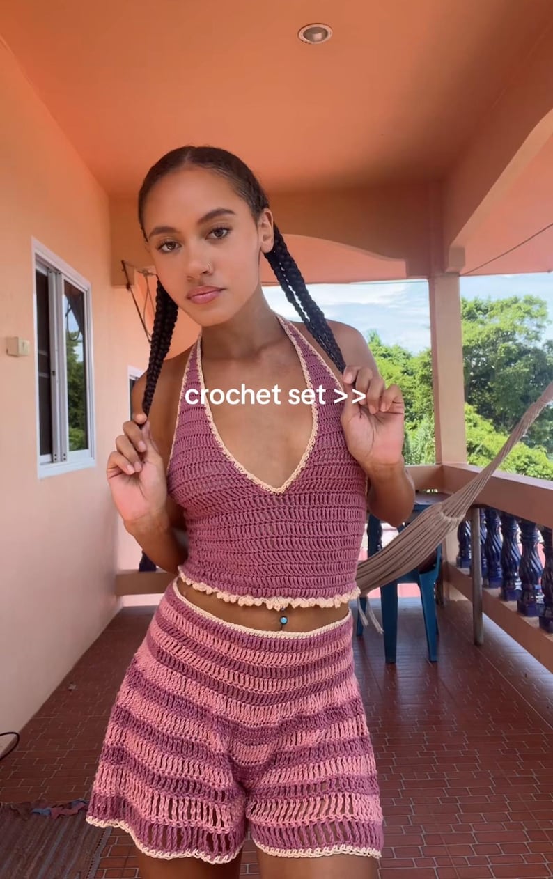 Puede incluir: Conjunto de crochet en tonos rosa y malva. El top halter y los shorts presentan un punto texturizado con un borde festoneado. El texto "crochet set >>" es visible.