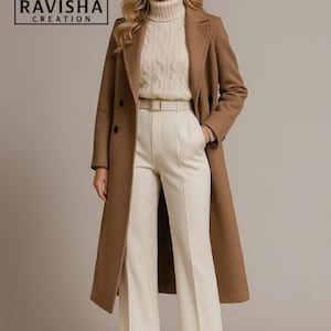 May include: A woman in a long brown coat, cream-coloured sweater, and white trousers. The coat has a double-breasted design and a belt. The trousers are wide-legged. The logo "RAVISHA CREATION" is in the top left corner.