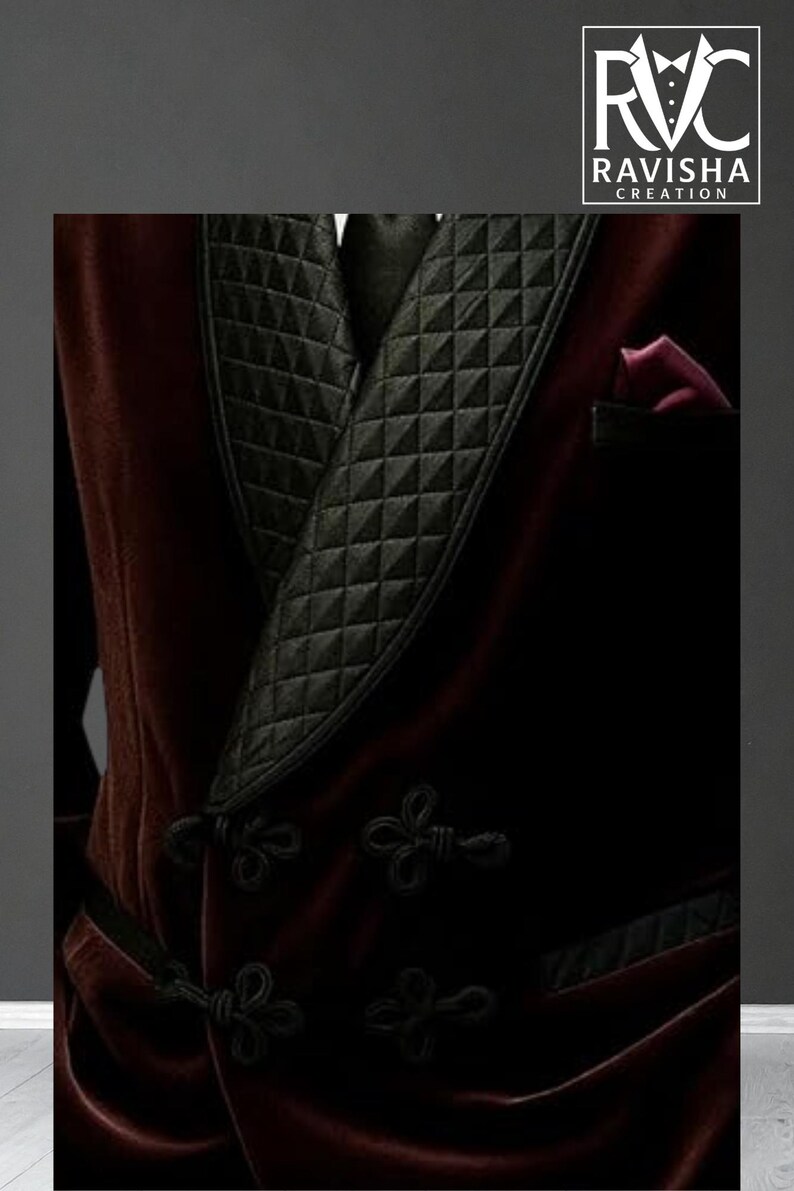 May include: A close-up of a burgundy velvet smoking jacket with a black quilted lapel and black frog closures. The jacket has a pocket with a burgundy lining. The logo "RAVISHA CREATION" is in the upper right corner.
