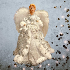 May include: A decorative angel figurine with a white dress, feathered wings, and a bow. The angel has red hair and is adorned with silver accents and faux fur trim. The figurine is a Christmas tree topper.