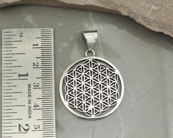May include: A silver pendant featuring a detailed Flower of Life design within a circular frame. The pendant is approximately 1.5 inches in diameter and includes a small loop for a chain. The image also shows a ruler with the text "MADE IN INDIA".