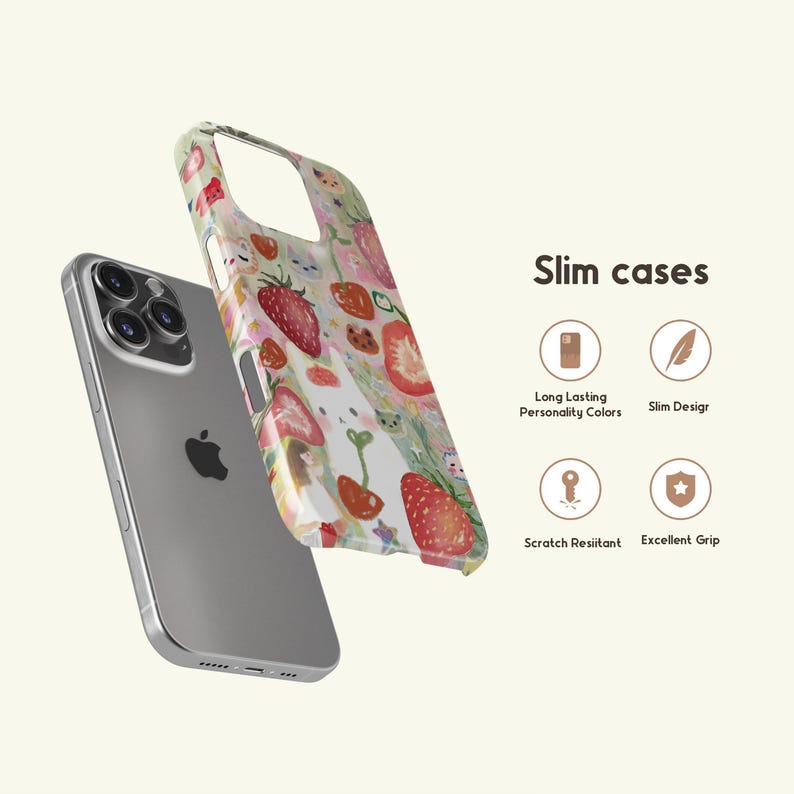 May include: A silver smartphone with a clear case featuring a colorful strawberry pattern. The case is decorated with red strawberries, green leaves, and other fruit illustrations. The text "Slim cases" is also visible.