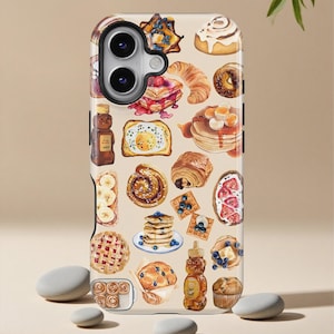 Puede incluir: Una funda de teléfono con un diseño de acuarela de varios alimentos para el desayuno, incluyendo panqueques, croissants y pasteles. La funda tiene un fondo beige y un acabado brillante, con un recorte para la cámara en la parte superior.