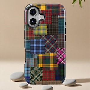 May include: A phone case with a patchwork design featuring various plaid patterns in red, blue, green, and yellow. The case has a black border and a camera cutout. The overall design is a mix of classic and modern styles.