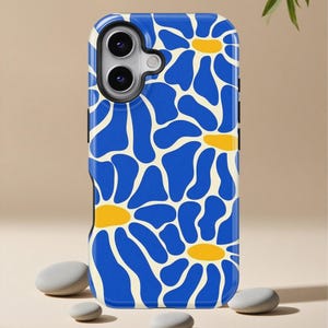 May include: A phone case featuring a blue floral pattern with yellow centers on an off-white background. The case has a black border and a camera cutout. The design is a repeating pattern of stylized flowers.