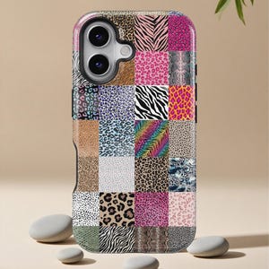 Puede incluir: Una funda de teléfono con diseño de patchwork que presenta varios estampados de animales, incluyendo cebra, leopardo y piel de serpiente. La funda combina colores vibrantes como rosa, morado y marrón, creando un diseño audaz y llamativo. Diseñada para un smartphone.