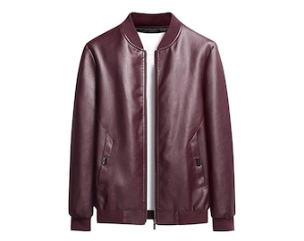 May include: A burgundy bomber jacket with a full-length zip, ribbed collar, cuffs, and hem. The jacket has two front pockets and a white undershirt is visible. The jacket is made of a smooth, leather-like material.