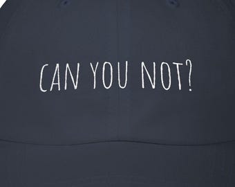 May include: Navy blue baseball cap with a curved brim. The cap features the white text "CAN YOU NOT?" across the front. The hat is a classic style, suitable for casual wear.