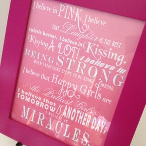 Peut inclure: Une impression encadrée rose avec un fond blanc et un dégradé rose. L'impression présente une citation sur la croyance en le rose, le rire, les baisers, la force, les filles heureuses et les miracles. La citation est attribuée à Audrey Hepburn.