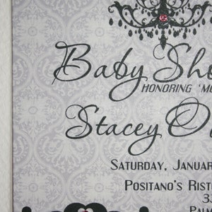 Peut inclure: Une invitation &agrave; une baby shower avec un fond &agrave; motif de damas gris. L'invitation pr&eacute;sente un texte en noir qui dit "Baby Shower" et "Stacey O". Un lustre noir et un graphique de berceau sont &eacute;galement inclus, chacun avec un bijou rose.