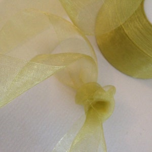 May include: A roll of yellow sheer ribbon with a shimmery finish. The ribbon is rolled up and the end is loose.