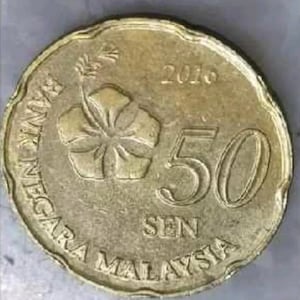 Puede incluir: Una moneda de 50 sen de color dorado de Malasia, con fecha de 2016. La moneda presenta una flor de hibisco y las palabras "BANK NEGARA MALAYSIA" y "SEN". La moneda tiene un borde festoneado.
