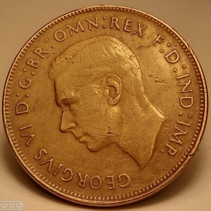 May include: A bronze coin featuring a profile of a man, surrounded by text. The coin's edge has a textured pattern. The text includes the words "GEORGIVS VI D:G:BR:OMN:REX F:D:IND:IMP."