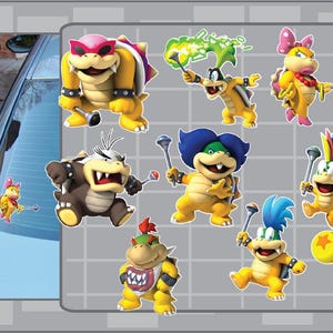 May include: A collection of colorful cartoon character stickers, featuring various characters with yellow, brown, and green skin tones. Each character is depicted in a dynamic pose, holding a mallet or other accessories. The stickers are set against a gray background.