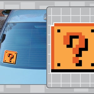 May include: A pixelated image of a question mark block from the Super Mario Bros. video game. The block is orange with a black question mark and black outlines. The block is on a white background with a grid pattern.