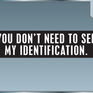 May include: A black and white sign with the text "YOU DON'T NEED TO SEE MY IDENTIFICATION."