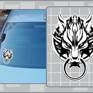 May include: Black and white vinyl car decal featuring a stylized wolf head design with a ring in its mouth. The decal is shown on a car's rear window, with a larger version of the design displayed on a gray background.