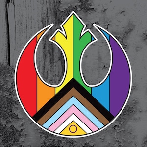May include: A colorful graphic featuring the Rebel Alliance symbol, incorporating the colors of the Pride flag. The design includes red, orange, yellow, green, blue, and purple, with additional colors representing the Progress Pride flag.