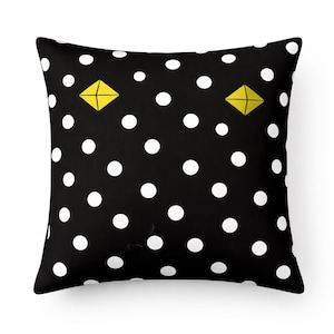 Peut inclure: Coussin carré noir à pois blancs et deux formes de losanges jaunes. Ce coussin présente un design simple et moderne, parfait pour ajouter une touche de couleur et de motif à n'importe quelle pièce. Le coussin est probablement fait d'un matériau doux et confortable.