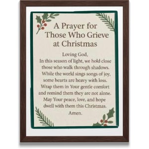 May include: A framed print with the text "A Prayer for Those Who Grieve at Christmas." The print has a cream-colored background with a green border and decorative holly and pine sprigs. The frame is a dark brown color.