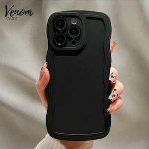 Op de afbeelding: Zwarte telefoonhoes met een golvend randontwerp. De hoes heeft een verhoogde rand rond de cameralenzen. De tekst "Venom Case" staat in de linkerbovenhoek.