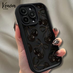 May include: Black phone case with a cherry pattern. The case has a matte finish and features a repeating design of dark cherries with stems and bows. The brand name "Venom Case" is printed in a cursive font in the upper left corner.