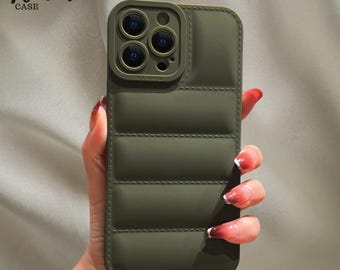 May include: Olive green phone case with a quilted design. The case has a raised camera lens protector and the text "Venom CASE" in the upper left corner. The case is designed for a smartphone.