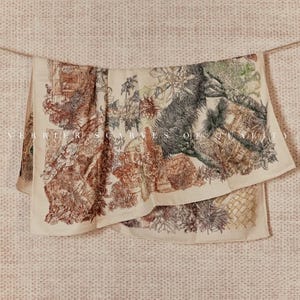 Könnte beinhalten: Ein cremefarbener Schal mit einem detaillierten, mehrfarbigen Toile-Druck von Gartenszenen, Blattwerk und architektonischen Elementen. Der Text "VERRIER SCARVES OF QUALITY" ist in einer hellen Schrift mittig auf dem Stoff aufgedruckt.