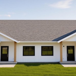 Pode incluir: Um duplex branco com portas de garagem e acabamentos pretos. O edifício tem um telhado cinzento e é rodeado por relva verde e céu azul. As portas e janelas são pretas, e as paredes exteriores são brancas.