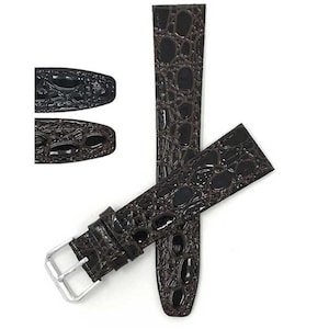 May include: Dark brown watch strap with a crocodile skin pattern. The strap has a silver-colored buckle and a glossy finish. The image also shows a close-up of the strap's end.