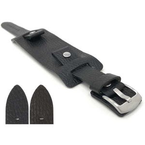 May include: A black leather watch strap with a wide cuff design. The strap features a silver-colored buckle and a textured surface. Two additional strap pieces are visible below the main strap.