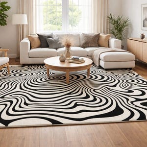 May include: A large area rug with a black and white swirling pattern dominates the living room. The rug's design creates an optical illusion, with curved lines resembling water ripples. The room also features a white sectional sofa, wooden furniture, and a round coffee table.