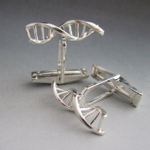 Pu&ograve; includere: Gemelli d'argento con un design a doppia elica di DNA. I gemelli sono realizzati in metallo lucido e hanno un aspetto classico.