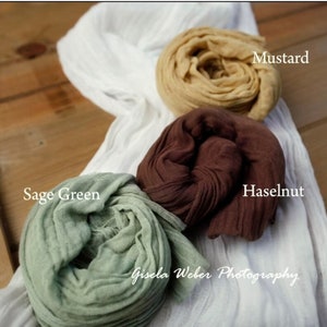 May include: Three fabric swaths in different colors: sage green, hazelnut brown, and mustard yellow. The fabric is crinkled and gathered, creating a soft and textured look.