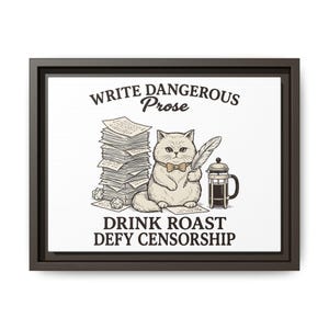 May include: A framed wall art print featuring a cat wearing a bow tie, holding a quill, sitting next to a tall stack of papers and a French press. The text reads: WRITE DANGEROUS Prose, DRINK ROAST, DEFY CENSORSHIP. The design is in black and brown ink.