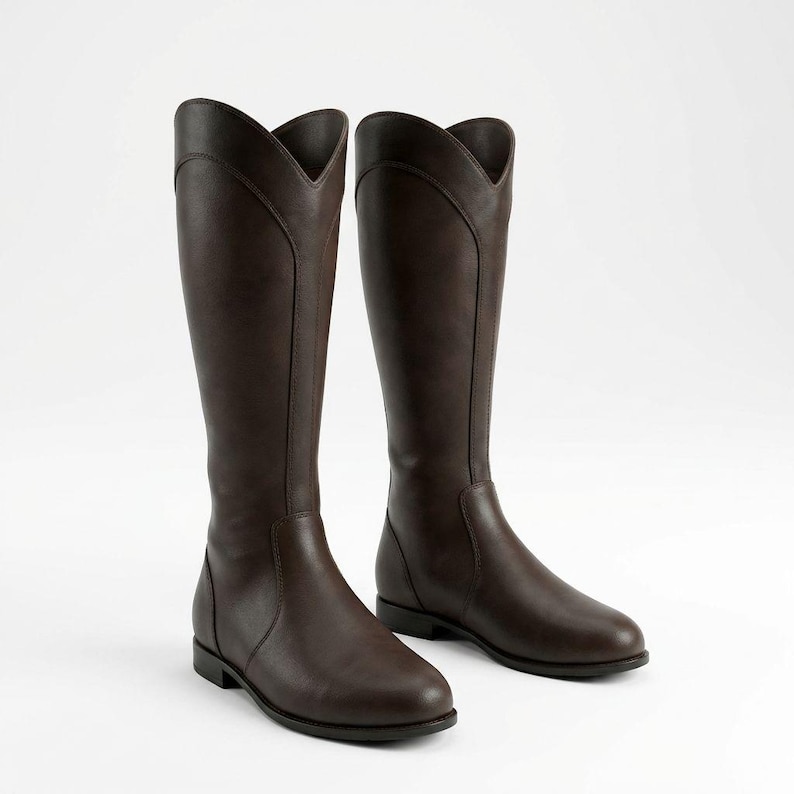 May include: A pair of tall, brown riding boots. The boots have a classic design with a V-shaped top and a smooth, leather-like appearance. The boots are knee-high and have a low heel.