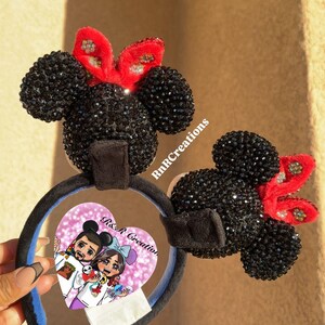 May include: Black Minnie Mouse ear headbands with red bows. The ears are covered in black rhinestones. The headband has a blue interior and a black velvet band. A heart-shaped image with cartoon characters is attached.