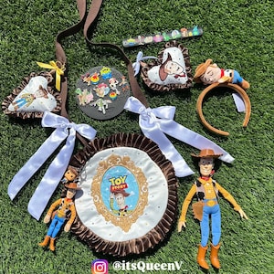 May include: A collection of Toy Story themed accessories including a round bag with a brown ruffled edge and a central Toy Story logo, a brown strap, two heart-shaped ornaments, a headband with a Woody figure, and several small character pins.