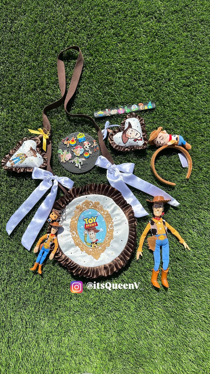 May include: A collection of Toy Story themed accessories including a round bag with a brown ruffled edge and a central Toy Story logo, a brown strap, two heart-shaped ornaments, a headband with a Woody figure, and several small character pins.