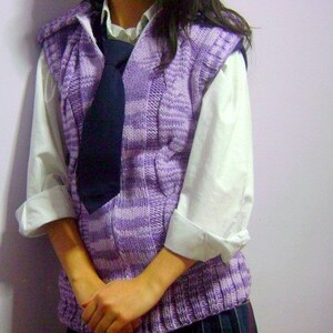 May include: A purple and white striped knitted vest with a dark blue tie. The vest has a zipper and a hood.