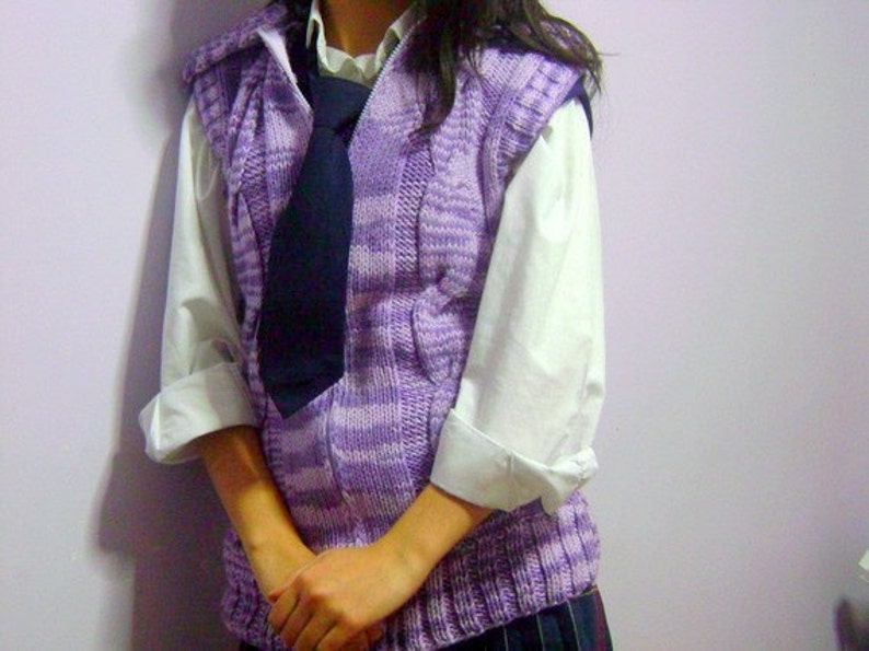 May include: A purple and white striped knitted vest with a dark blue tie. The vest has a zipper and a hood.