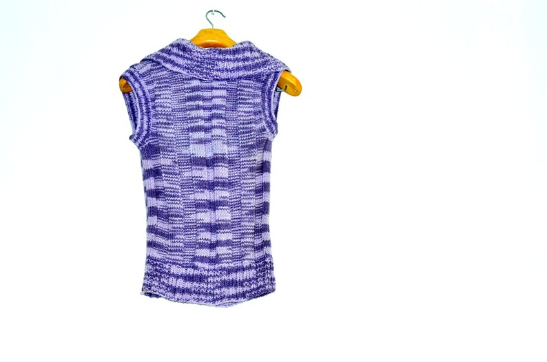 May include: A purple and white striped sleeveless sweater with a turtleneck collar hanging on a wooden hanger.